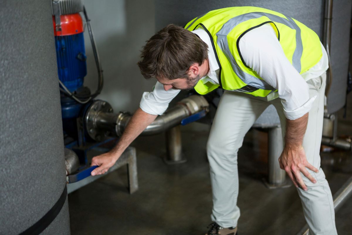Male worker fixing the leak in factory